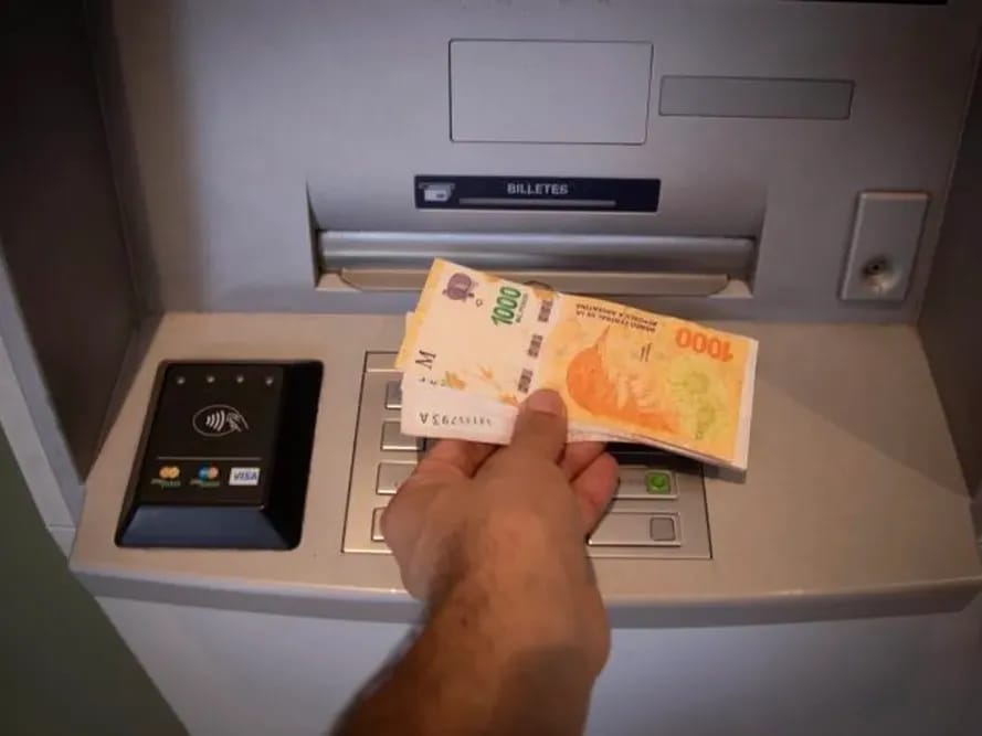 Un hombre retira dinero de una terminal de cajero